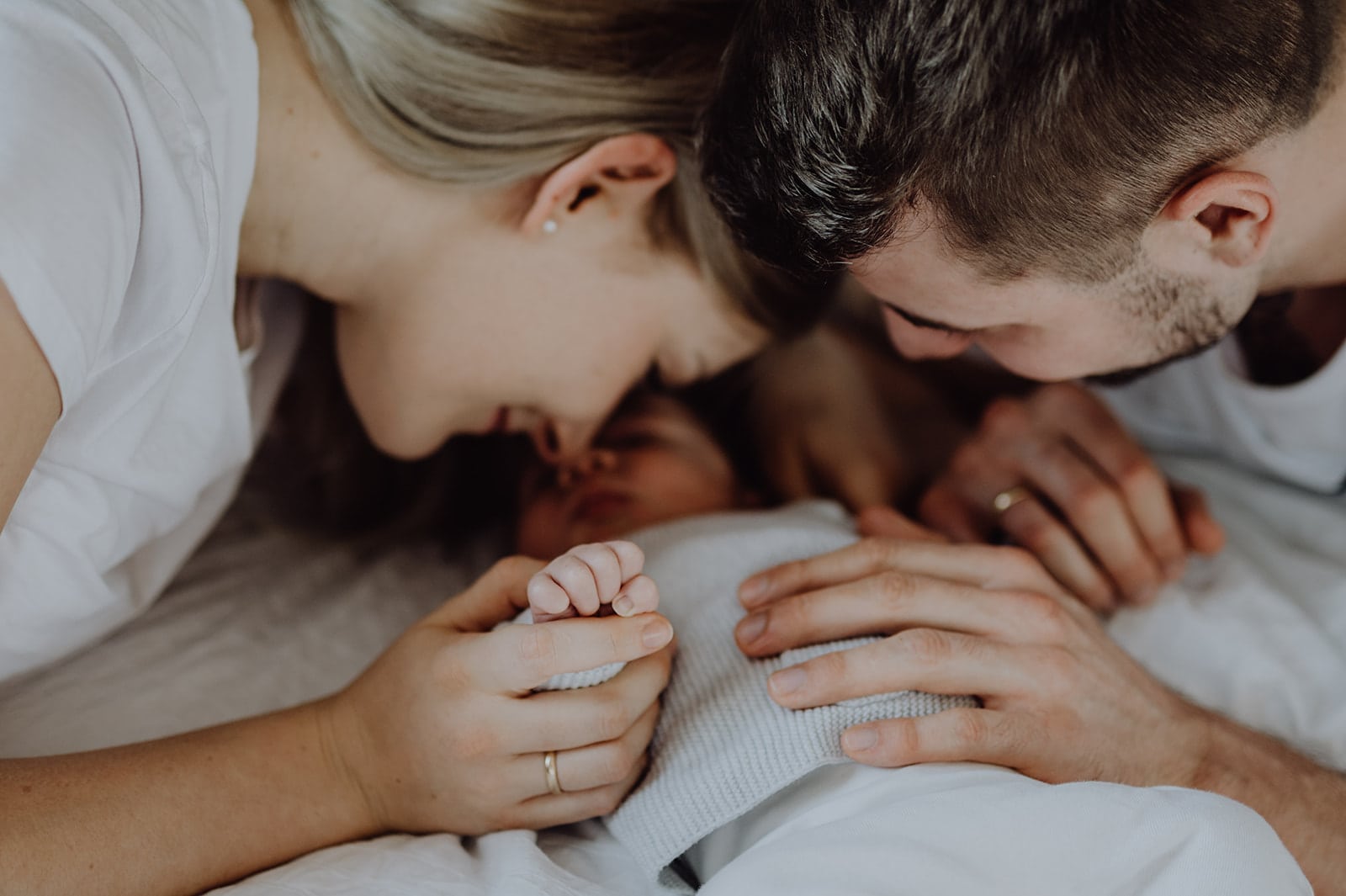 Mutter, Vater & Baby auf dem Bett